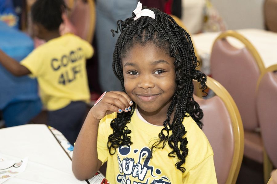 A Sunshine Band girl smiling in her yellow shirt